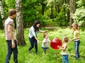 Outdoor happy family plaing ball . Royalty Free Stock Photo