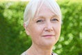 Outdoor Head And Shoulders Portrait Of Serious Senior Woman