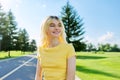 Outdoor headshot portrait of positive teenage blonde girl