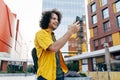 Outdoor horizontal shot of young man have a online meeting group conversation on mobile phone while walking in the street. Happy Royalty Free Stock Photo