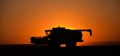 the silhouette of a tractor is driving through the sunset at sunset Royalty Free Stock Photo