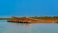 Outdoor industrial jetty at river bank with incline large conveyor for transportation bauxite ore from mining shuttle trains to