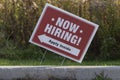 Outdoor lawn sign now hiring apply inside