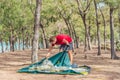 Outdoor lifestyle eco sport tourist put up set up green campsite, summer forest near lazur sea. Man assembling study