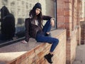 Outdoor lifestyle fashion portrait of pretty young girl, wearing in hipster swag grunge style on urban background. Wearing hat and Royalty Free Stock Photo