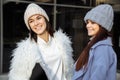 Outdoor fashion portrait of two pretty cheerful girls friends, smiling and having fun. Walking on the autumn city Royalty Free Stock Photo