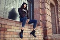 Outdoor lifestyle portrait of pretty young girl, wearing hipster swag grunge style on urban background. Wearing hat and jeans Royalty Free Stock Photo