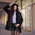 Outdoor lifestyle portrait of pretty young girl, wearing hipster swag grunge style on urban background. Wearing hat and jeans Royalty Free Stock Photo