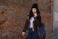 Outdoor lifestyle portrait of pretty young girl, wearing hipster swag grunge style on urban background. Wearing hat and jeans with Royalty Free Stock Photo