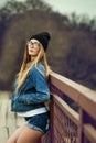Outdoor lifestyle portrait of pretty young girl, wearing in hipster swag grunge style urban background. Retro vintage toned image Royalty Free Stock Photo