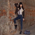 Outdoor lifestyle portrait of pretty young girl, wearing hipster swag grunge style on urban background. Wearing hat and jeans with Royalty Free Stock Photo