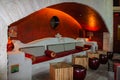 Outdoor lit sitting area in an arch with concrete ornate bench and tables and footstools