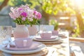 Outdoor lunch table setting with flowers. Romantic table setting with tablecloth, plates, crystal goblets, beautiful Royalty Free Stock Photo