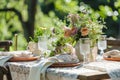 Outdoor lunch table setting with flowers. Romantic table setting with tablecloth, plates, crystal goblets, beautiful Royalty Free Stock Photo