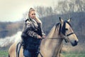 Outdoor northern warrior woman with braided hair and war makeup holding shield and ax with wolf next to her ready to attack -