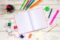 Outdoor notebook surrounded by school supplies on a white wooden background with empty space for inscriptions. Royalty Free Stock Photo