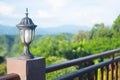 Outdoor old lantern on green nature in the park background.