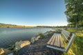 Outdoor park bench with an amazing view of lake mountain and sky on a sunny day Royalty Free Stock Photo