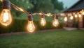 outdoor party string lights hanging in backyard on green bokeh background with copy space Royalty Free Stock Photo