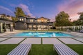 Outdoor patio area with a swimming pool located near the side of a modern house Royalty Free Stock Photo