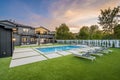 Outdoor patio area with a swimming pool located near the side of a modern house Royalty Free Stock Photo