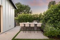 a patio with a bbq and white dining set on it