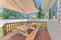 Outdoor patio with sunshade and wooden table with seats