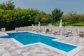 Outdoor patio with a swimming pool and sun loungers. Royalty Free Stock Photo