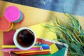 Outdoor photo of art working dekstop with colored felt pens, cup of coffee and paints