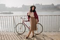 Outdoor photo of good-looking dark-haired girl in skirt spending time near river. Full-length portrait of wonderful