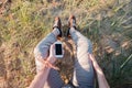 Outdoor photo of man sitting on grass holding phone with blank screen. Royalty Free Stock Photo