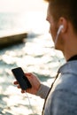 Outdoor photo of man using a cellphone, standing near the sea Royalty Free Stock Photo