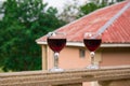 Outdoor picnic setting with wine or glass of wine on balcony with green field and mountains on background