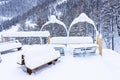 Outdoor picnic table and chairs covered in a thick layer of untouched deep snow. Snow-covered park on the mountains. Royalty Free Stock Photo