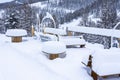 Outdoor picnic table and chairs covered in a thick layer of untouched deep snow. Snow-covered park on the mountains. Royalty Free Stock Photo