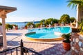 Outdoor pool with vibrant crystal water, parasols and deck chairs located on the coast of Garda lake in amazing La Ca camping in Royalty Free Stock Photo