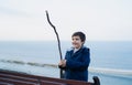 Outdoor portrait Active kid playing with wooden stick with blurry blue ocean seaside background, Happy boy having fun playing by