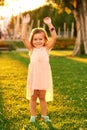 Outdoor portrait of adorable 3 or 4 year old girl playing in summer park Royalty Free Stock Photo