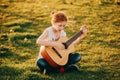 Outdoor portrait of adorable 9 year old kid girl playing guitar outdoors Royalty Free Stock Photo