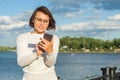 Outdoor portrait attractive happy middle aged woman female freelancer blogger traveler with phone on nature Royalty Free Stock Photo