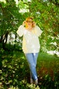 Outdoor portrait of a beautiful blonde middle-aged woman near blossom apple trees with white flowers Royalty Free Stock Photo