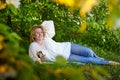 Outdoor portrait of a beautiful blonde middle-aged woman near blossom apple trees with white flowers Royalty Free Stock Photo