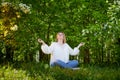 Outdoor portrait of a beautiful blonde middle-aged woman near blossom apple trees with white flowers Royalty Free Stock Photo