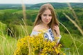 Outdoor portrait of beautiful blonde woman, attractive young girl in camomile field with flowers. Young beautiful girl in the fiel