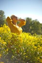 Outdoor portrait of a beautiful blonde woman relaxing near blossom yellow flowers. selective focus on the flowers. Vacation Royalty Free Stock Photo