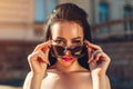 Outdoor portrait of beautiful brunette woman with make-up wearing sunglasses. Topless fashion model taking glasses off Royalty Free Stock Photo