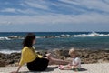 Outdoor portrait of beautiful darkhair mother and her cute blonde daughter.