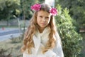 Outdoor portrait of beautiful girl child blonde with wreath of fresh pink flowers Royalty Free Stock Photo