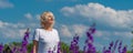 Outdoor portrait of a beautiful happy middle aged blonde woman in a field with flowers Royalty Free Stock Photo