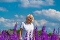 Outdoor portrait of a beautiful happy middle aged blonde woman in a field with flowers Royalty Free Stock Photo